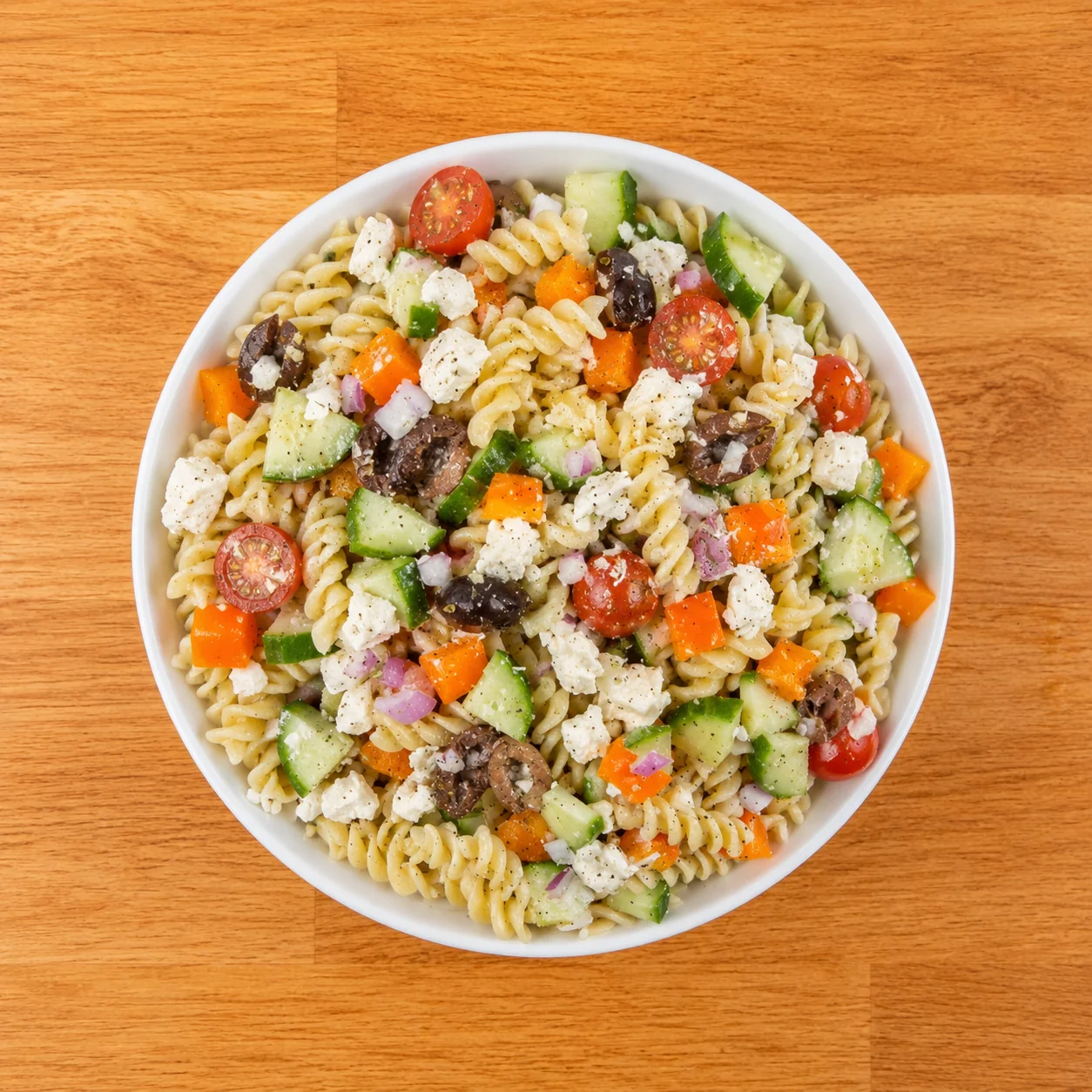 The best Greek pasta salad in a large white bowl