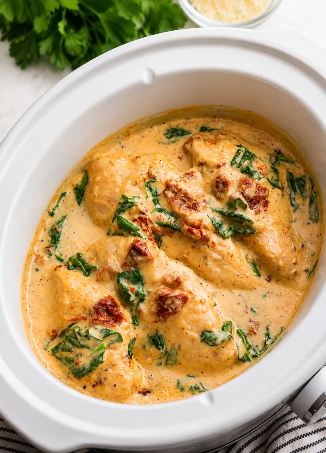 Chicken breasts in a creamy Italian herb sauce in a white slow cooker