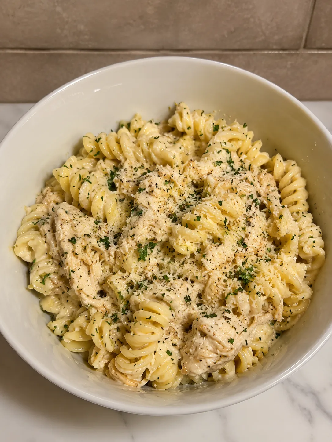 Creamy garlic parmesan chicken pasta in a white bowl