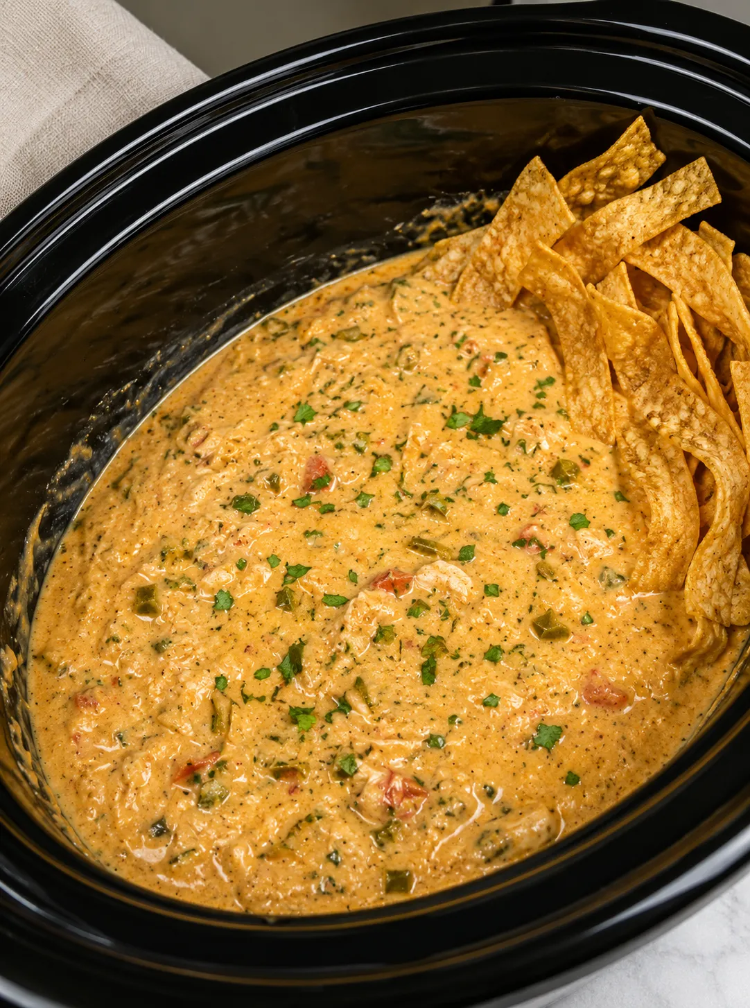 Creamy white chicken chili in a crockpot with tortilla chips