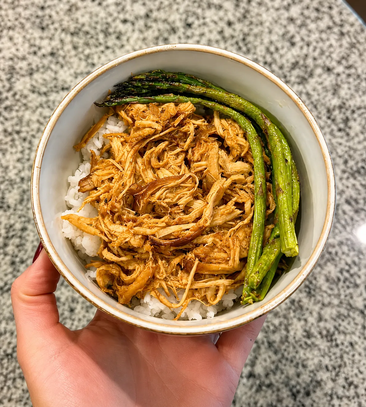 Shredded honey garlic chicken over rice with roasted asparagus