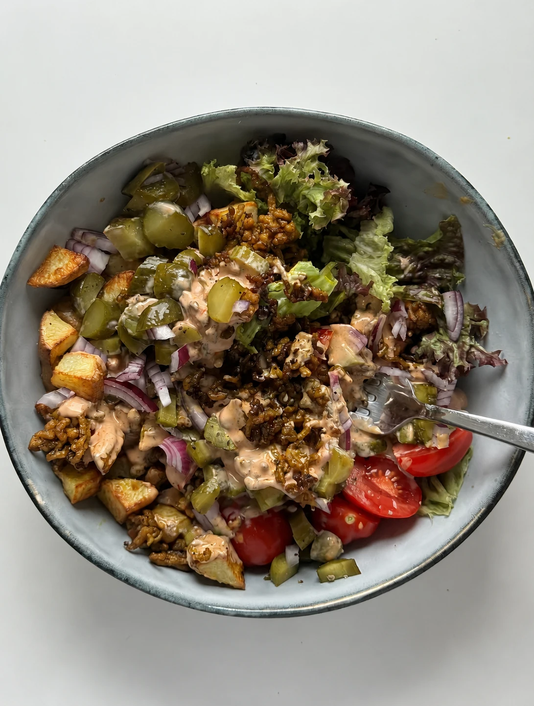 Big Mac-style salad bowl with ground beef, pickles, and burger sauce