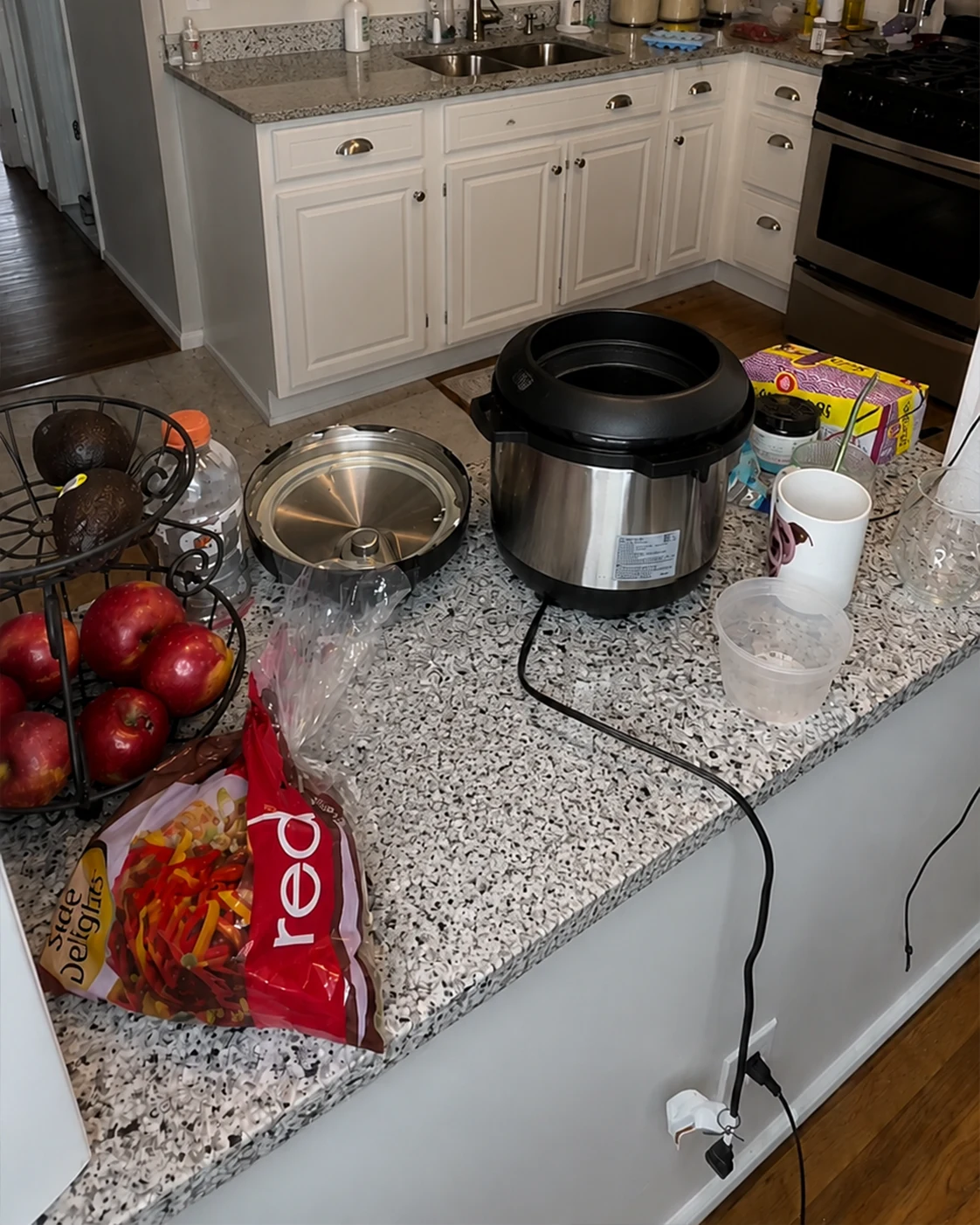 College kitchen counter with Instant Pot, apples, avocados, and bagged potatoes