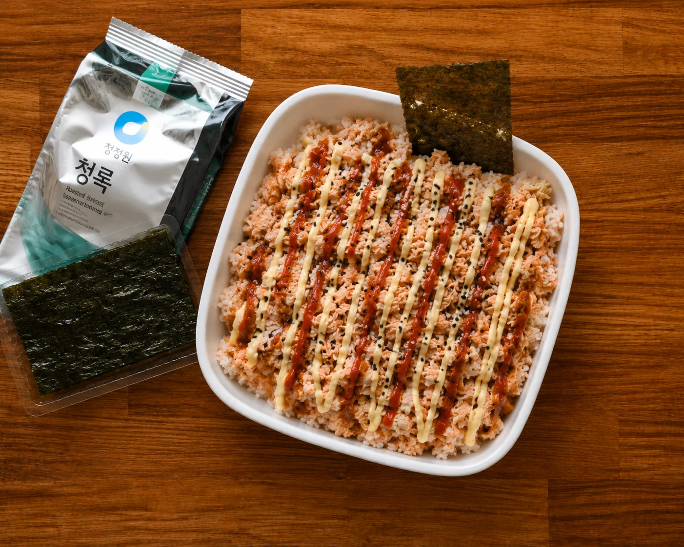 Viral salmon rice bowl topped with spicy mayo, sesame seeds and seaweed